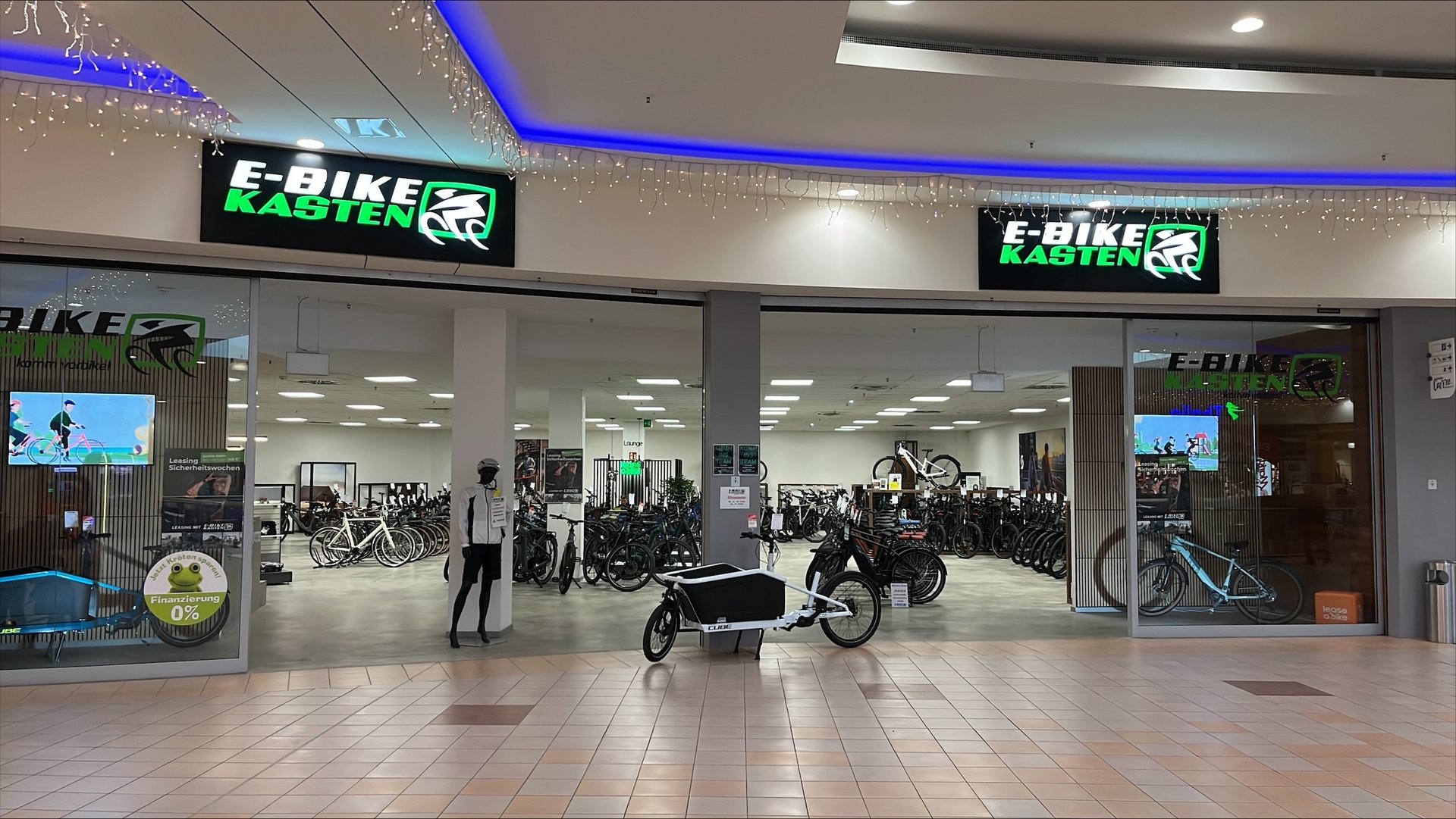E-Bike-Geschäft im Einkaufszentrum mit Ausstellungsrädern und Cargo-Bike im Eingangsbereich.